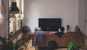 Woman in apartment on couch in front of a TV